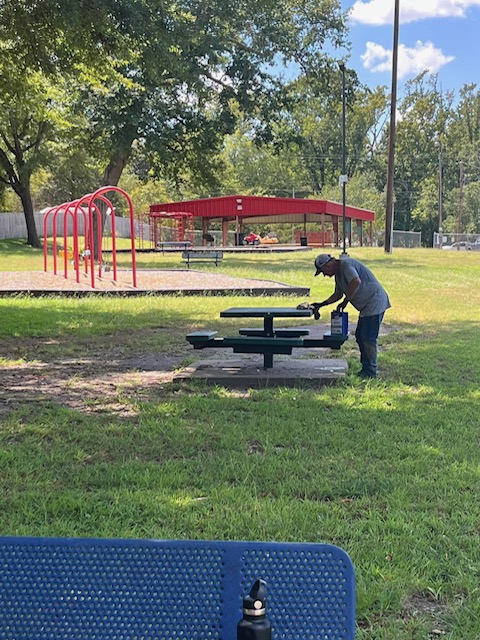 Image of Worker Cleaning Picnic Tables